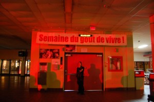 agente de sécurité montant la garde dans une cafétéria déserte....notez l'ironie avec la banderole!!